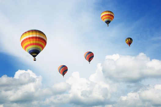 Hot-air balloons in the cloudy blue sky