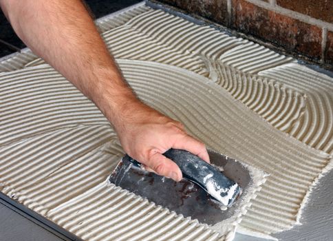 construction worker laying mortat on floor