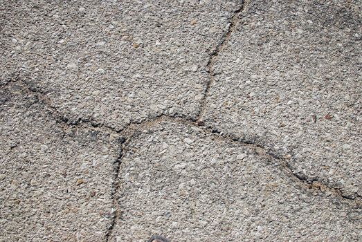 Fragment of old cracked asphalt road close up