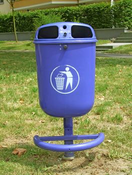 Blue garbage basket with the symbol, on green background