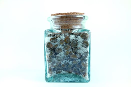 jar of salted capers over white background