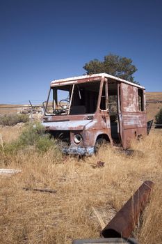 An old abandoned vintage delivery truck van in a field