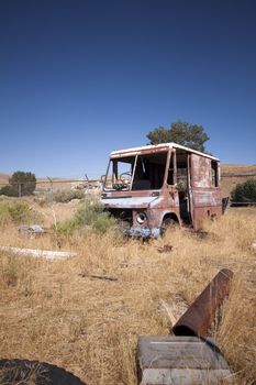 An old abandoned vintage delivery truck van in a field