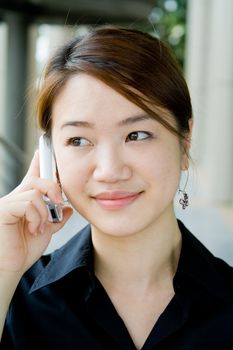 Beautiful and pretty asian business woman posing with mobile phone