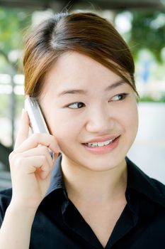 Beautiful and pretty asian business woman posing with mobile phone