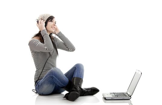 Young woman working with a laptop and listen music at the same time