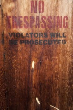 spray painted no trespassing on wood wall