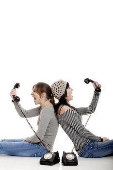 Two young women talking with old telephones - Isolated on white