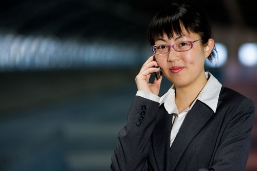 Asian business woman posing with mobile or hand phone, modern communication