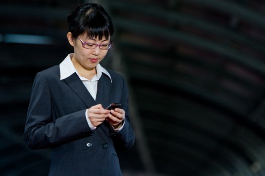 Asian business woman posing with mobile or hand phone, modern communication