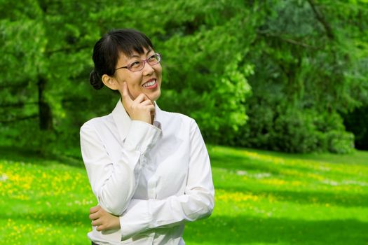 Environmentally friendly asian business woman outdoors in nature with green grass