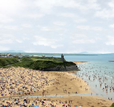 ballybunion beach crowded with people on a hot day with castle