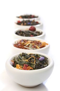 Various bowls of premiun tea leaves blends, over white