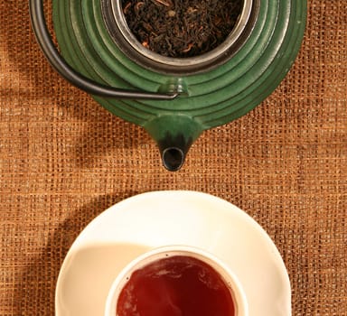 Chinese teapot with tea leaves and a cup of tea