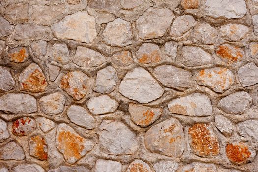 Rough quarry stone and mortar wall background texture pattern.