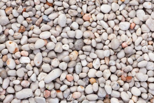 Naturally rounded gravel at sea shore. Nature background texture pattern.