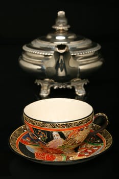 Silver teapot and an antique chinese cup of tea. More in gallery