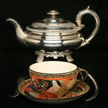 Silver teapot and an antique chinese cup of tea. More in gallery