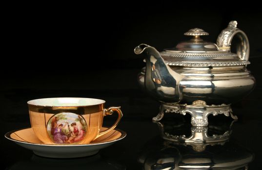 Silver teapot and an antique chinese cup of tea. More in gallery