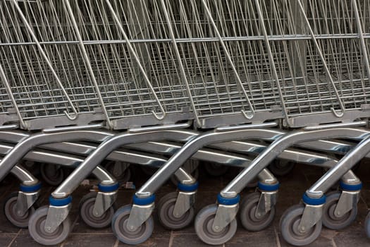 Detail of shiny metal shopping carts stacked in a row.