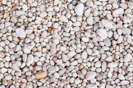 Naturally rounded gravel at sea shore. Nature background texture pattern.