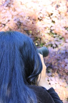 Woman photographer holding a photo camera outdoors.