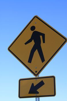 Road crossing sign over blue sky.