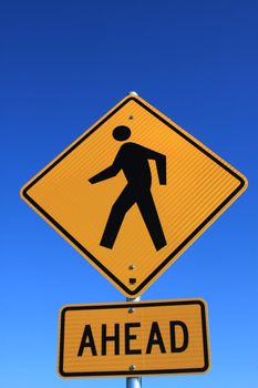 Road crossing sign over blue sky.