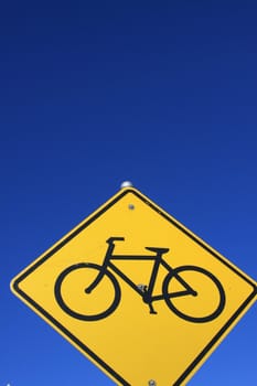 Bike lane road sign over blue sky.