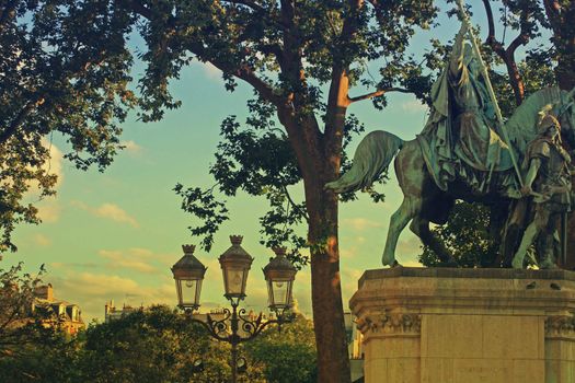 Scene opposite Notre Dame Cathedral, Paris France. Looking towards the center of Paris. Statue in view with street lights at dusk. A vintage retro effect has been applied to the image.