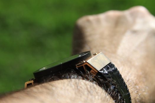 Man's hand with the gold watch on.