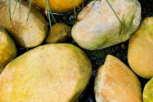 Yellow boulders laying in water