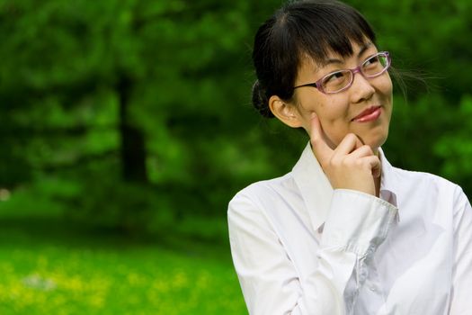 Environmentally friendly asian business woman outdoors in nature with green grass