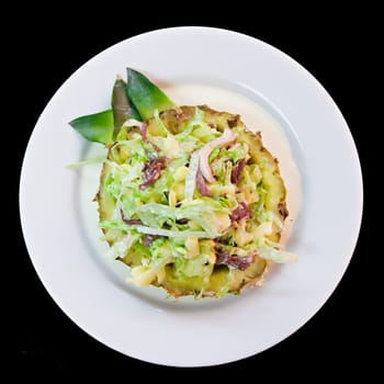 Salad with pineapple on a white plate