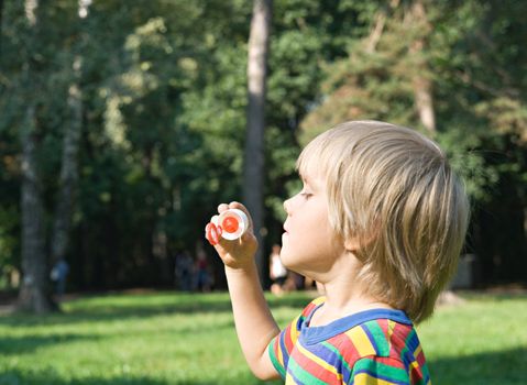 Little boy with soap bubbles, outdoor shot
