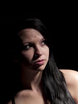 a teen girl with moody light on black