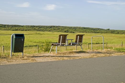 An empty bench in the dunes looking out to sea, in the Netherlands