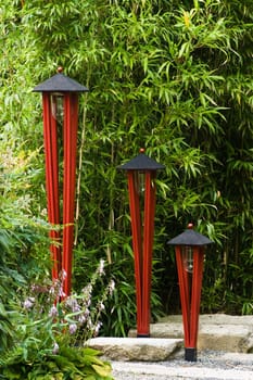 Red painted wooden lamps to illuminate a Japanese garden