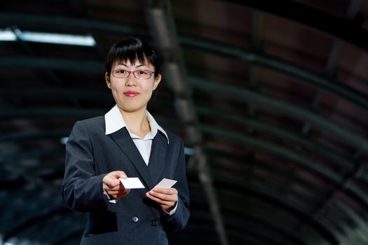 Asian woman giving her business calling card with a friendly smile