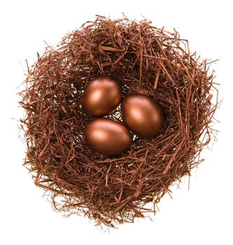 Three eggs in a nest of bronze colour on a white background
