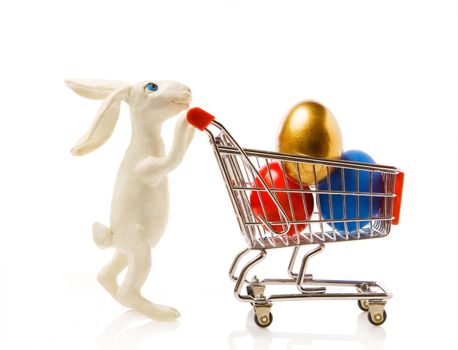 Easter rabbit carries the cart with multi-coloured eggs
