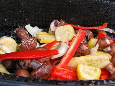 An assortment of vegetables cooking on an outdoor grill.