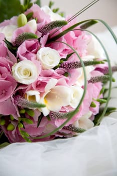 Beautiful wedding bouquet lying on top of the veil