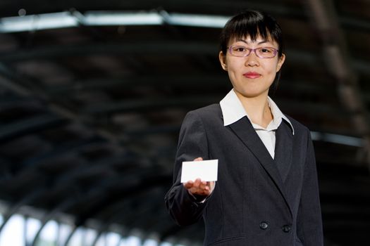 Asian woman giving her business calling card with a friendly smile