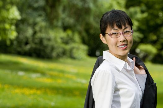 Environmentally friendly asian business woman outdoors in nature with green grass