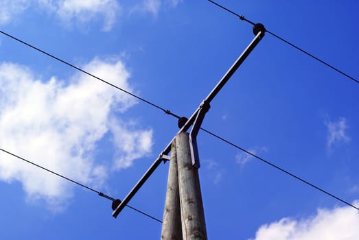 Old electric pillar against a blue sky.