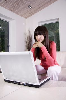 Woman sitting on a sofa using a laptop
