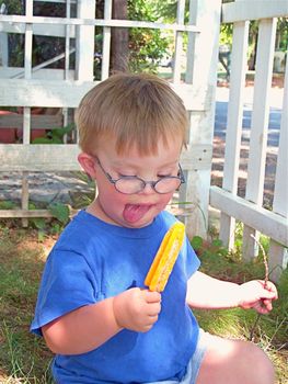 Boy with Downs Syndrome eating a popsicle