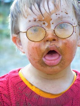 Downs Syndrome boy with mud on his face