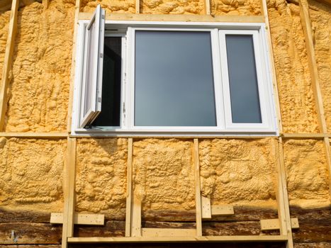 Renovation of old house: wall is sprayed with liquid insulating foam before the siding goes on.